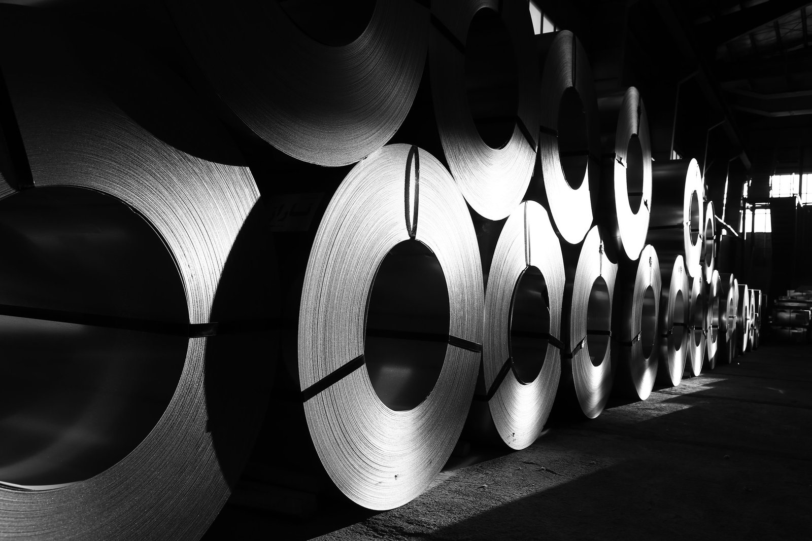 Rows of rolled steel coils with tightly layered strip edges.