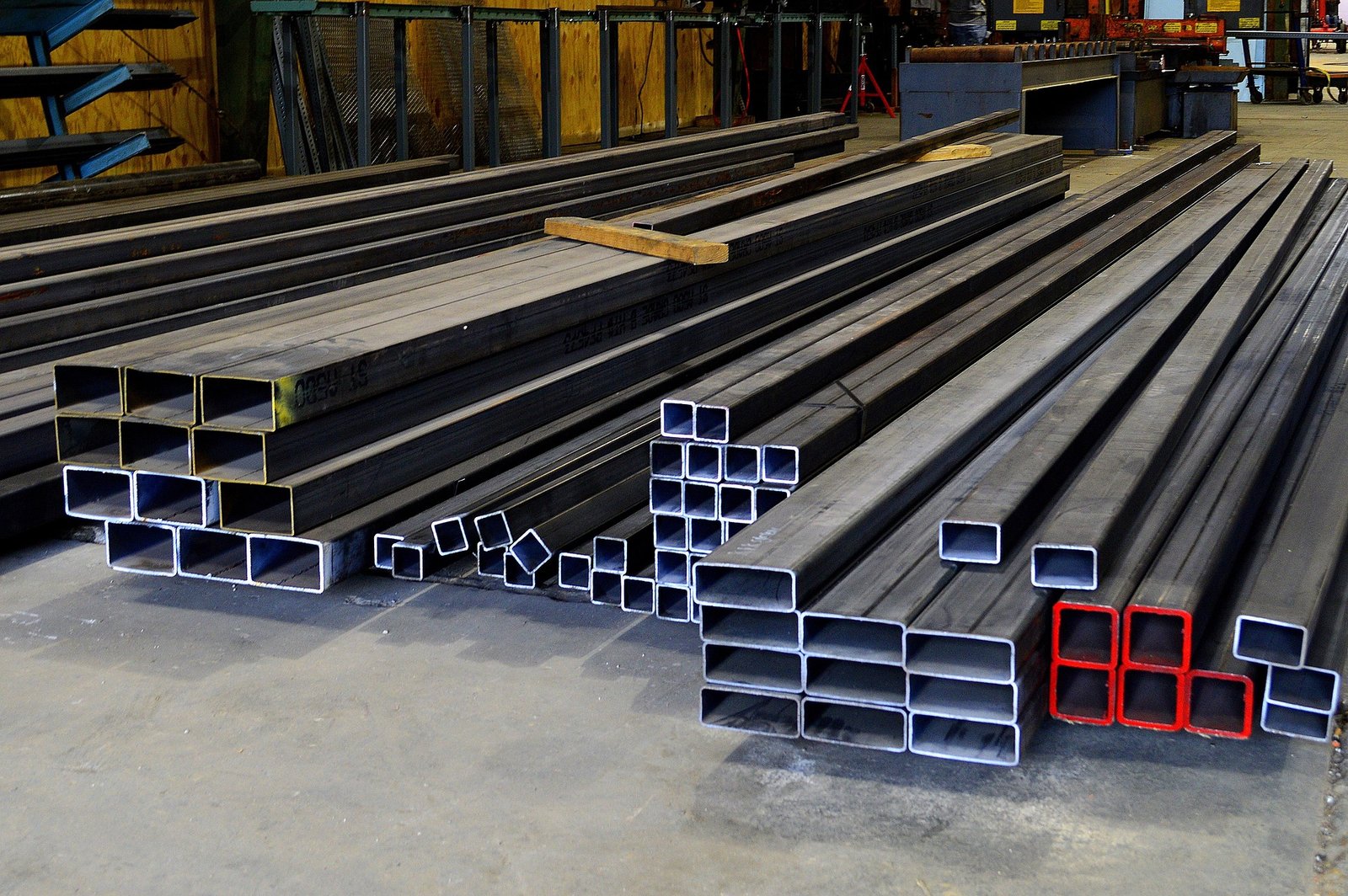 Square and rectangular steel hollow sections stacked in long lengths, with their open ends visible.