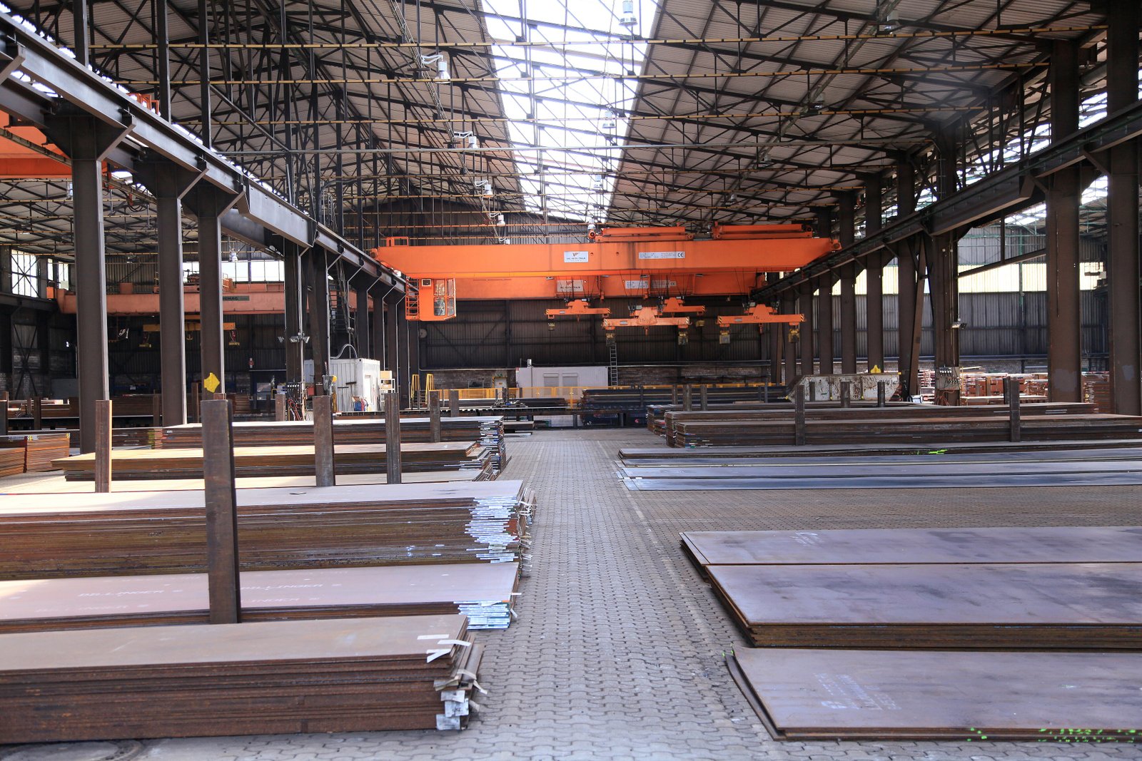 Flat steel plates stacked in layers with broad faces and visible cut edges.